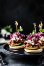 Gourmet sliders with pulled pork, pickles, and coleslaw on black plate Royalty Free Stock Photo