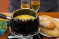 Gourmet Swiss fondue dinner with assorted cheeses and a heated pot of cheese fondue with colorful forks dipping inside Royalty Free Stock Photo