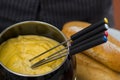 Gourmet Swiss fondue dinner with assorted cheeses and a heated pot of cheese fondue with colorful forks dipping inside Royalty Free Stock Photo