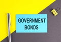 GOVERNMENT BONDS text written on sticky with pen on grey, yellow background, business concept