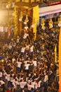 Govindas, young boys surrounded by crowd, making human pyramid to break Dahi Handi