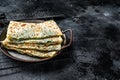 Gozleme Turkish flatbread with greens and cheese. Black background. Top view. Copy space