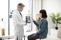 GP showing x-ray on tablet to lady in cervical collar Royalty Free Stock Photo