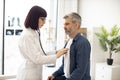 GP using stethoscope during patient's checkup in exam room Royalty Free Stock Photo