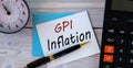 GPI INFLATION - words on a white sheet on the background of a calculator, alarm clock and pen Royalty Free Stock Photo
