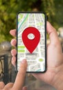 GPS App. Woman using smartphone with map and red pinpoint on screen