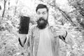GPS and navigation apps. Useful program. Smartphone online navigation. Man bearded wanderer walking in forest with