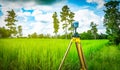 GPS surveying instrument install on tripod in green rice field Royalty Free Stock Photo