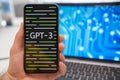 GPT 3 logo on the smartphone and neural network on laptop display