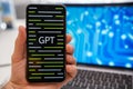 GPT logo on the smartphone and neural network on laptop display