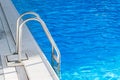 Grab bars ladder in the blue swimming pool Royalty Free Stock Photo