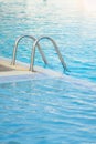 Grab bars ladder in the blue swimming pool. Royalty Free Stock Photo