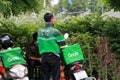 Grab bike in green corporate color of jacket and the box to put food. He is prepared to go to deliver food