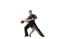 Grace and beautiful dancers, young couple dancing Argentine tango isolated on white studio background. Artists in black Royalty Free Stock Photo