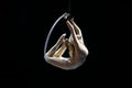 Graceful aerial acrobat doing her performance with a hoop isolated on black