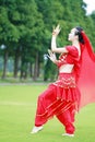 Graceful Asian Chinese belly dancer dancing on grass Royalty Free Stock Photo