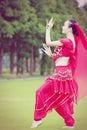 Graceful Asian Chinese belly dancer dancing on grass Royalty Free Stock Photo