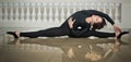 Graceful ballerina doing the splits on the marble floor. Gorgeous ballet dancer performing a split on glossy floor Royalty Free Stock Photo