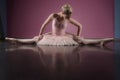 Graceful ballerina sitting with legs stretched out