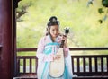 Elegant woman in Chinese traditional drama ancient costume play Chinese lute pipa guitar Royalty Free Stock Photo