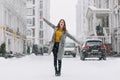Graceful caucasian female model in long coat dancing on the street in winter morning. Outdoor photo of charming lady in Royalty Free Stock Photo