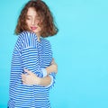 graceful curly woman in casual clothes on blue