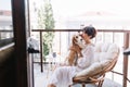 Graceful dark-haired woman in bathrobe kissing beagle dog and looking away thinking about something. Portrait of lady