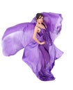 Graceful girl in flying purple silk dress