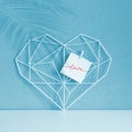 Graceful openwork heart on a pastel blue background. Minimalism. Concept Symbol of love and Valentine`s Day. Home Decor Royalty Free Stock Photo