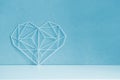 Graceful openwork heart on a pastel blue background. Minimalism. Symbol of love Royalty Free Stock Photo