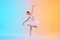 Graceful and poised young ballet dancer performs dance moves in action in neon light against blue-orange gradient