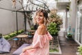 Graceful short-haired girl looking over shoulder in cozy street restaurant. Outdoor shot of pleasan