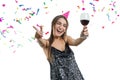 Graceful, smiling young brunette girl in party hat with glass of red wine dancing under confetti and laughing, white isolated Royalty Free Stock Photo