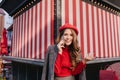 Graceful white lady with smartphone in hand have a good time outdoor. Brown-haired female model in sweater and beret Royalty Free Stock Photo