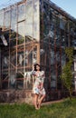 Graceful woman in dress on background of greenhouse building