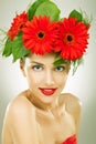 Gracefull young woman with red flowers in her hair Royalty Free Stock Photo