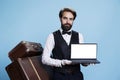 Gracious bellboy holds laptop