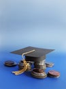 Grad cap and coins Royalty Free Stock Photo
