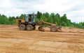 The grader clears away a ground