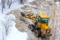 Grader clears the road from snow during a snowfall