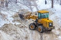 Grader clears the road from snow during a snowfall