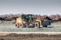 Grader dredges rubble on road construction Royalty Free Stock Photo