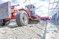 Grader is leveling ground at construction site, view on undercarriage