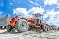 Grader is leveling ground at construction site, view on undercarriage