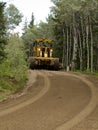 Grader resurfacing narrow rural road Royalty Free Stock Photo