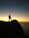 Gradient contrast seen on a cliff as the sun goes below the horizon with man silouette Royalty Free Stock Photo