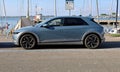 Blue Hyundai Ioniq 5, battery electric SUV, parked outside a marina pier.