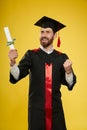 Graduate with beard holding diploma, showing hurray.