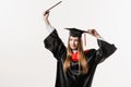 Graduate girl is graduating college and celebrating academic achievement. Happy girl student in black graduation gown Royalty Free Stock Photo