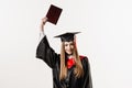 Graduate girl is graduating college and celebrating academic achievement. Happy girl student in black graduation gown Royalty Free Stock Photo